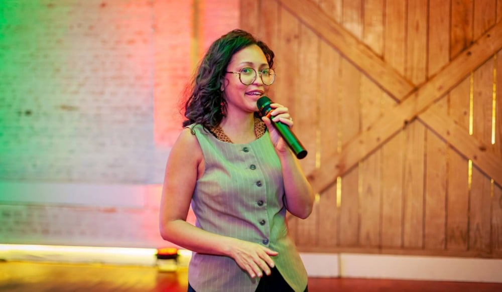 Mona Oliveira, fundadora e CEO da BioLinker, falando com um microfone
